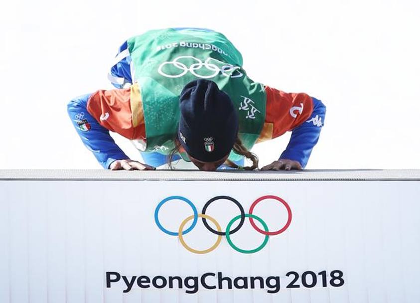 Prima di salire sul gradino più alto del podio olimpico Moioli bacia la superfice che calcherà un attimo dopo